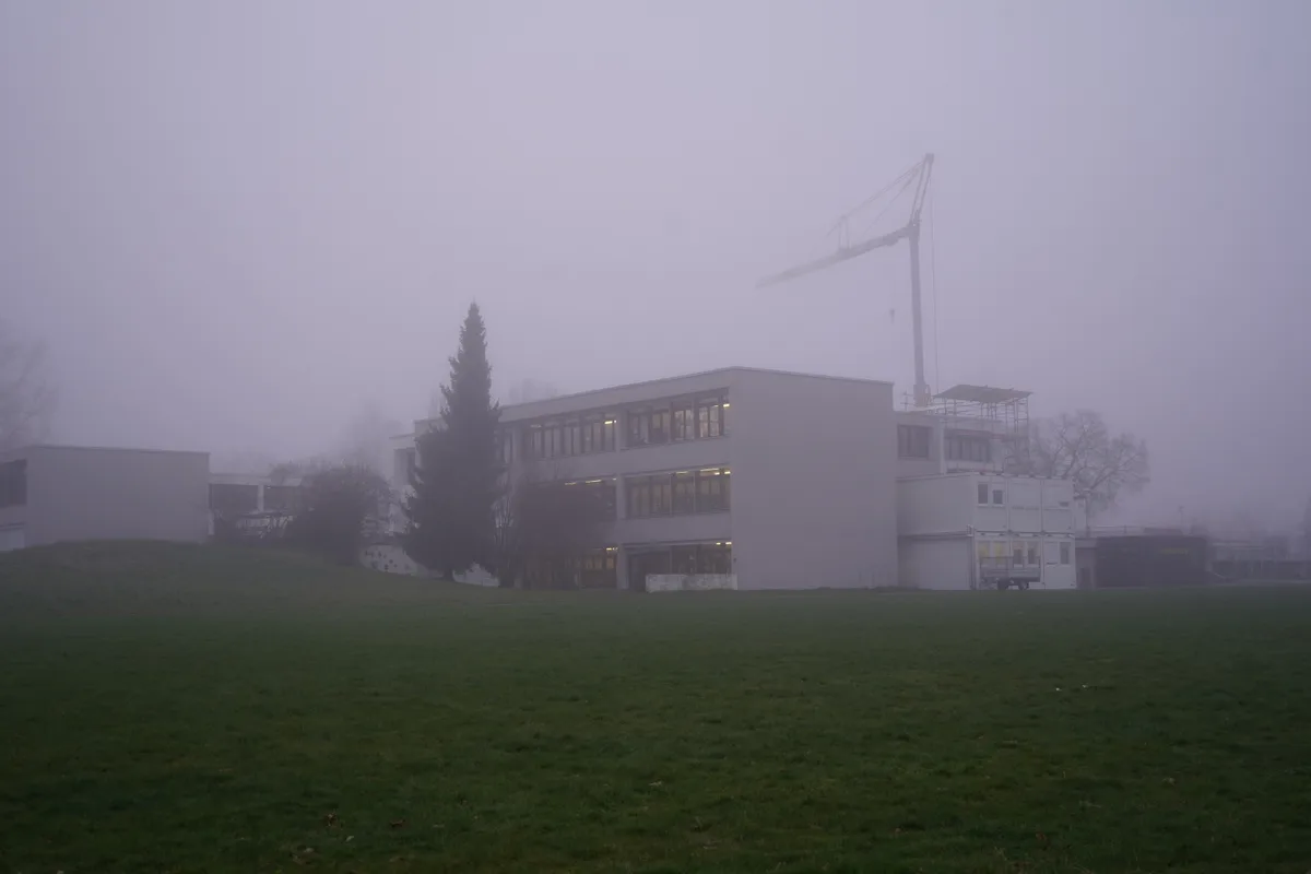 Das Schulhaus Breiti im Nebel.